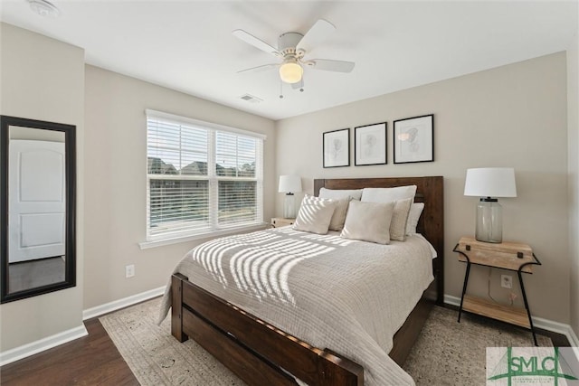 bedroom with visible vents, a ceiling fan, baseboards, and wood finished floors