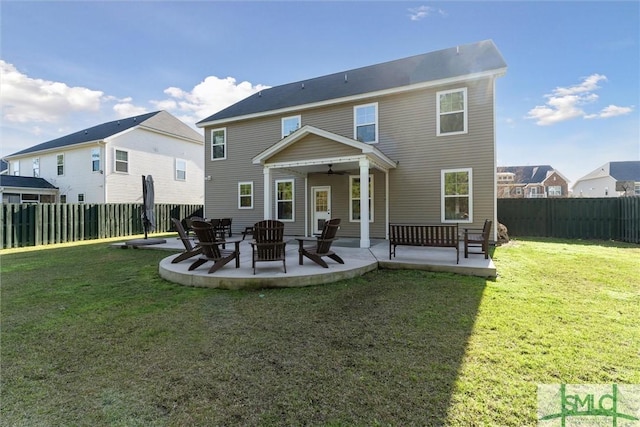 rear view of property with a ceiling fan, a patio area, a lawn, and a fenced backyard