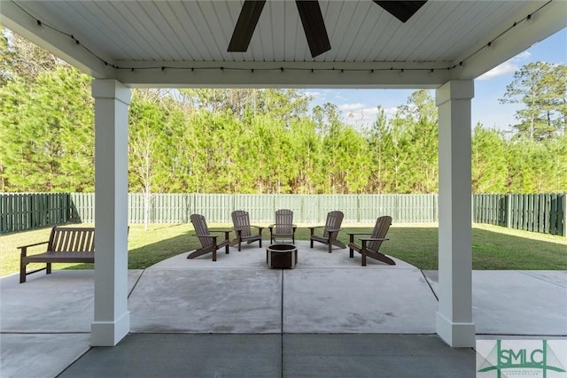 view of patio / terrace featuring a fenced backyard, a ceiling fan, and an outdoor fire pit