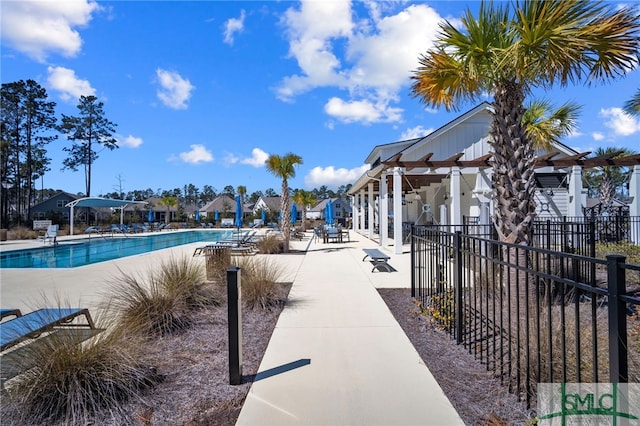 community pool with fence and a patio area