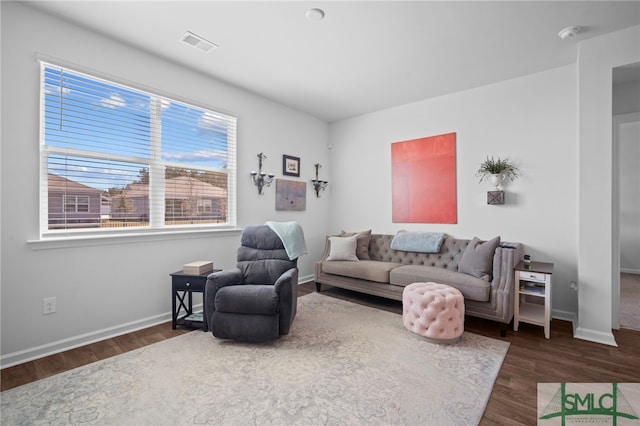 living area with visible vents, baseboards, and wood finished floors