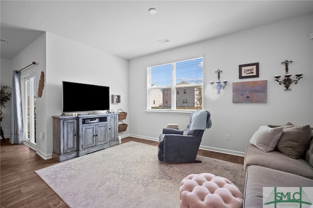 living area with visible vents, dark wood-type flooring, and baseboards