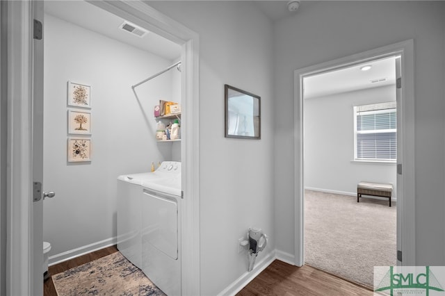 clothes washing area with washer and dryer, visible vents, baseboards, and laundry area