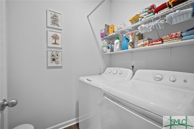 laundry area with laundry area, washing machine and dryer, and baseboards