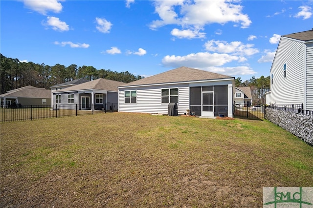 rear view of house with a yard, a fenced backyard, and a sunroom