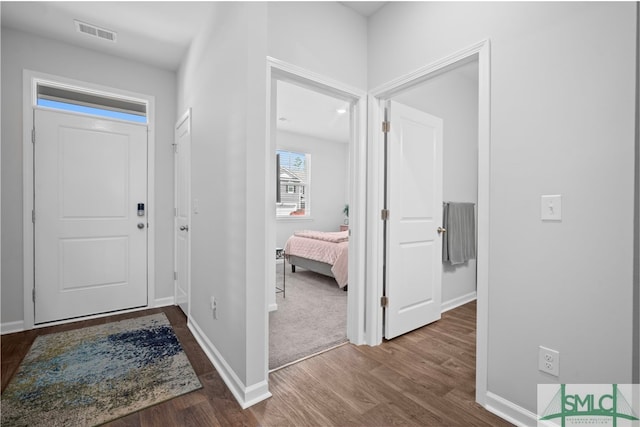 entryway featuring wood finished floors, visible vents, and baseboards