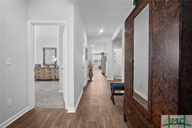 hallway featuring baseboards and wood finished floors