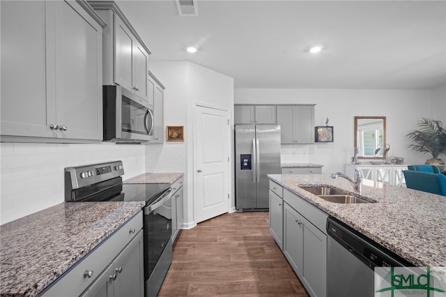 kitchen featuring visible vents, dark wood finished floors, a sink, gray cabinetry, and stainless steel appliances