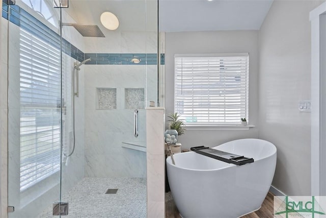 full bath featuring a shower stall and a freestanding tub