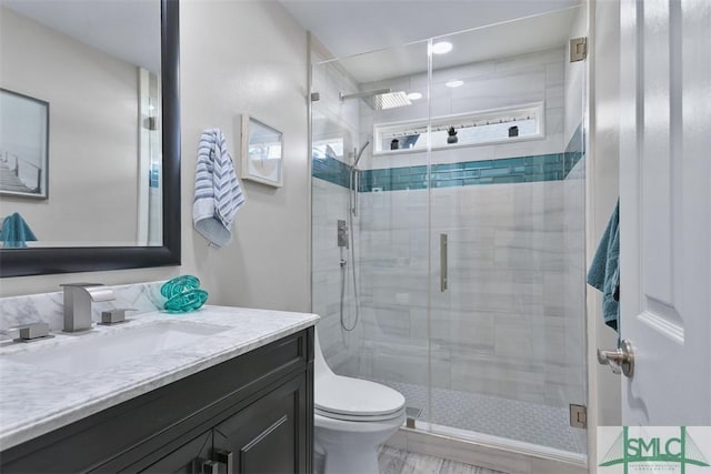 bathroom featuring vanity, toilet, and a stall shower