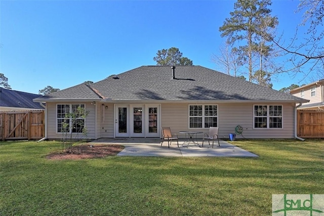 back of property featuring a gate, a patio, fence, a yard, and a shingled roof