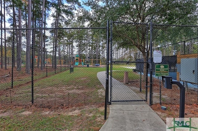 exterior space with playground community, fence, a yard, and a gate