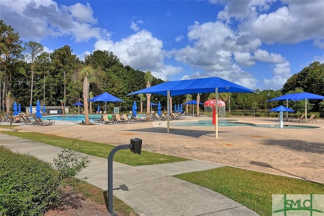 view of jungle gym featuring a community pool and a patio area