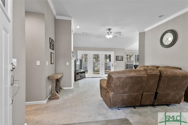 carpeted living area with crown molding, french doors, baseboards, and ceiling fan