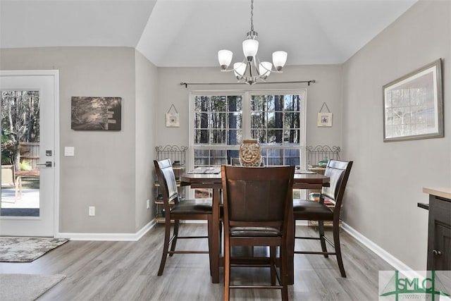 dining space with vaulted ceiling, light wood-style flooring, and baseboards