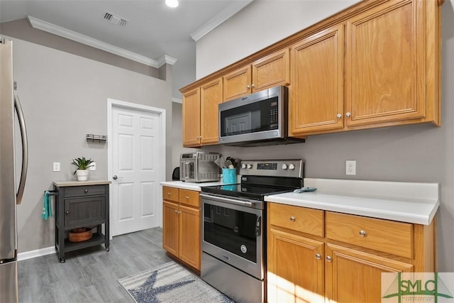 kitchen featuring crown molding, light countertops, visible vents, and appliances with stainless steel finishes