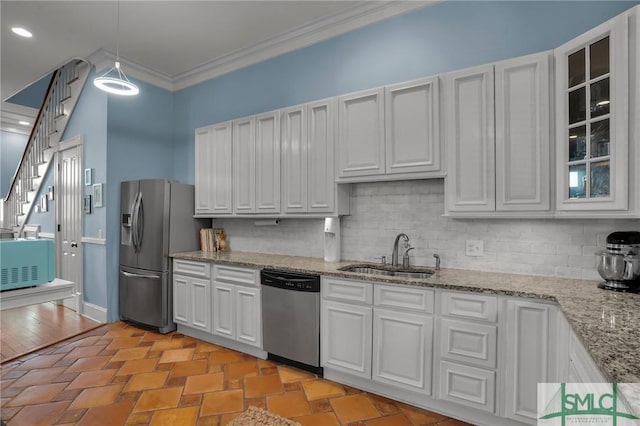 kitchen with decorative backsplash, ornamental molding, appliances with stainless steel finishes, and a sink