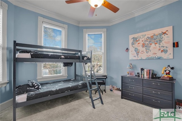 carpeted bedroom featuring crown molding, baseboards, and ceiling fan