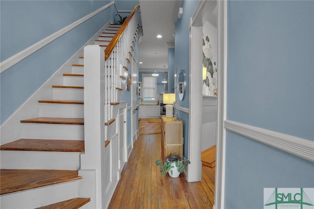 stairs with hardwood / wood-style floors and recessed lighting