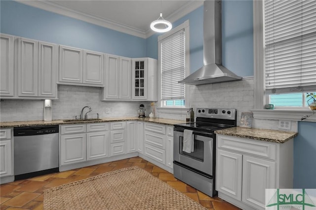 kitchen with ornamental molding, a sink, backsplash, stainless steel appliances, and wall chimney range hood