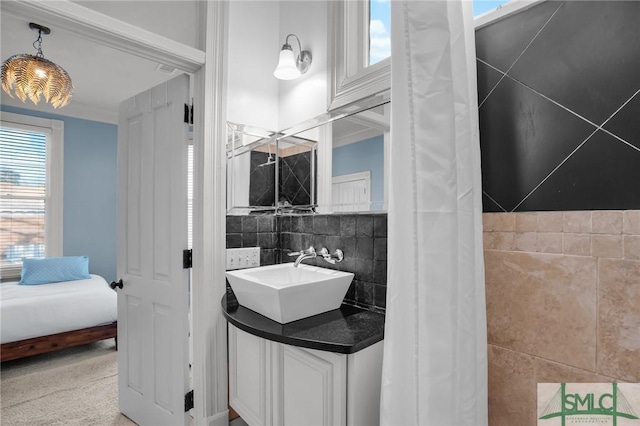 bathroom featuring backsplash, vanity, and tile walls