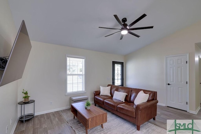 living area with vaulted ceiling, wood finished floors, baseboards, and ceiling fan