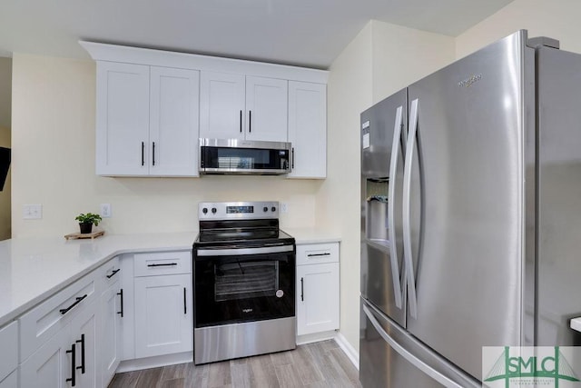 kitchen featuring light countertops, white cabinets, light wood finished floors, and appliances with stainless steel finishes