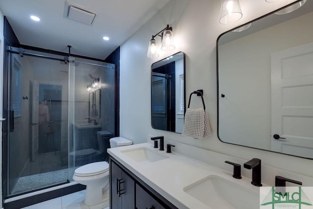 bathroom featuring a shower stall, toilet, visible vents, and a sink