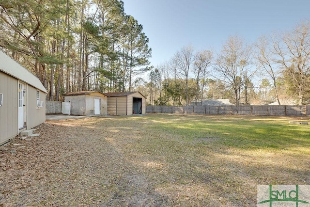 view of yard featuring an outbuilding, a storage shed, and a fenced backyard