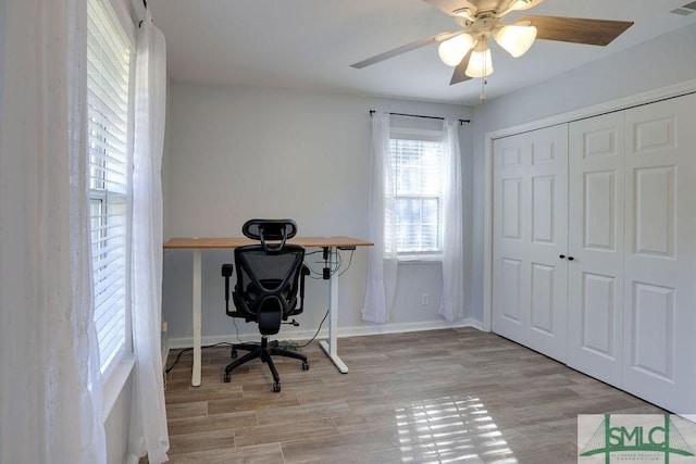 office featuring baseboards, light wood-type flooring, and ceiling fan