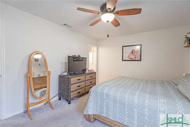 carpeted bedroom featuring a ceiling fan, visible vents, and baseboards