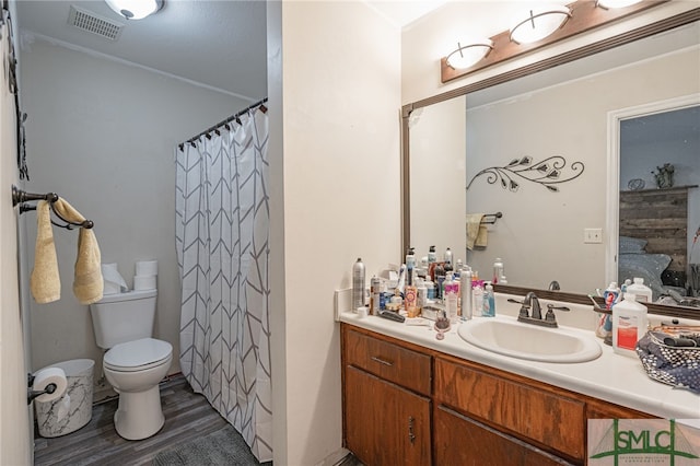 bathroom with vanity, a shower with shower curtain, wood finished floors, visible vents, and toilet