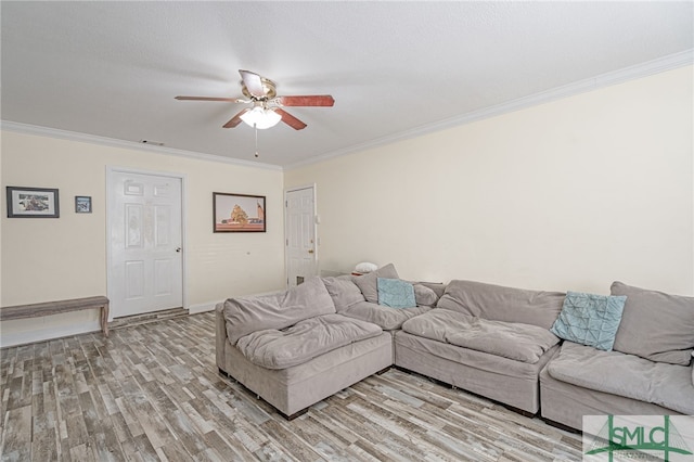 living room with visible vents, crown molding, baseboards, ceiling fan, and light wood-style flooring