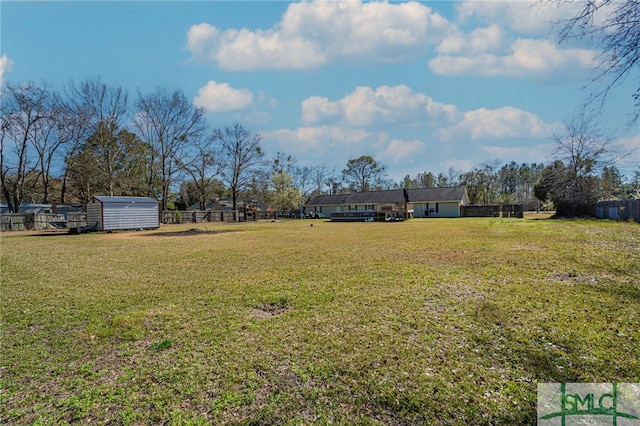 view of yard with a storage unit, an outdoor structure, and fence