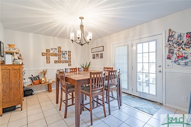 dining area with light tile patterned flooring, a wealth of natural light, and a chandelier