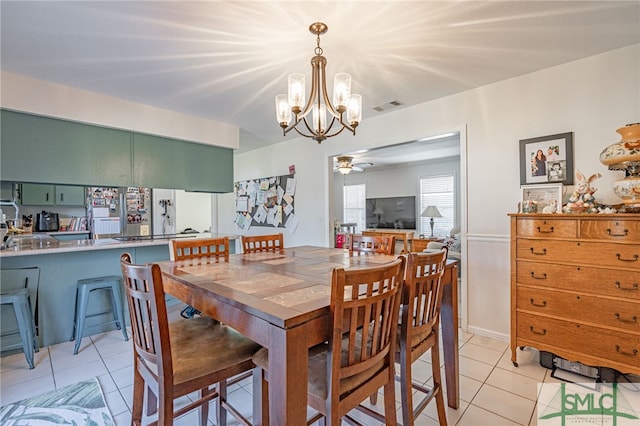 dining space featuring light tile patterned floors, ceiling fan with notable chandelier, and visible vents