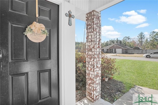 view of exterior entry featuring stucco siding and a yard