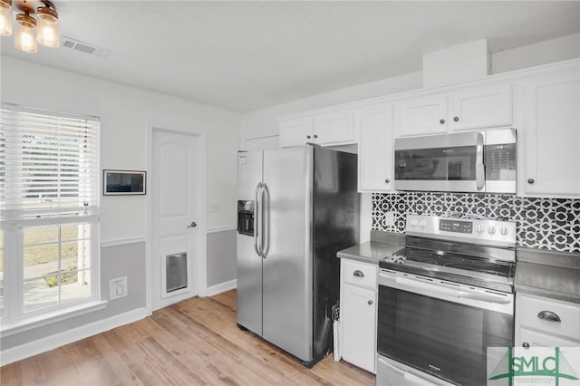 kitchen featuring white cabinets, a healthy amount of sunlight, visible vents, and stainless steel appliances