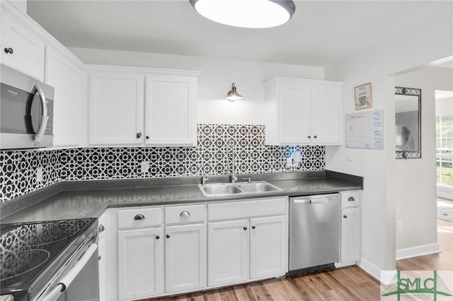 kitchen featuring a sink, white cabinets, backsplash, and stainless steel appliances