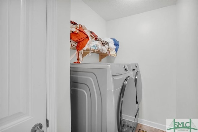 washroom featuring laundry area, independent washer and dryer, a textured ceiling, and baseboards