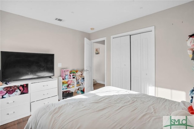 bedroom with visible vents, a closet, and wood finished floors