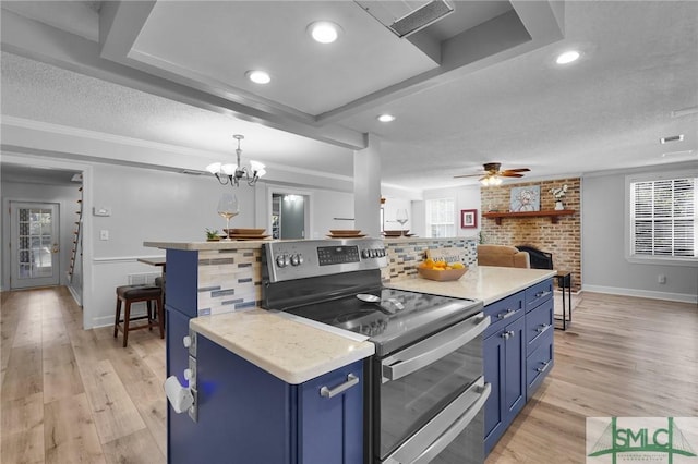 kitchen with range with two ovens, decorative backsplash, a textured ceiling, blue cabinets, and light wood-type flooring