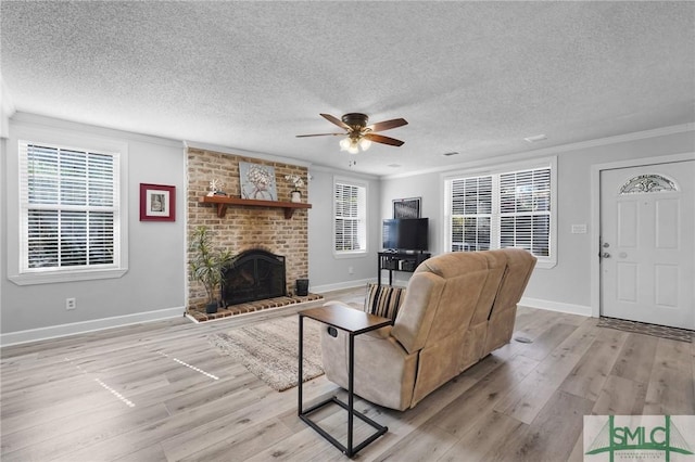 living room with a fireplace, light wood-type flooring, crown molding, and baseboards