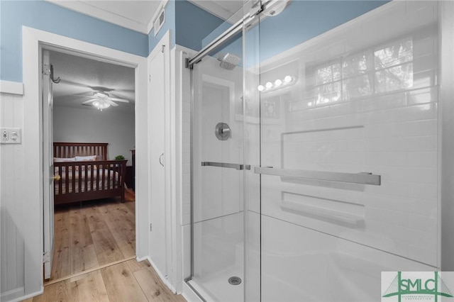 ensuite bathroom with visible vents, a stall shower, ensuite bathroom, wood finished floors, and ceiling fan