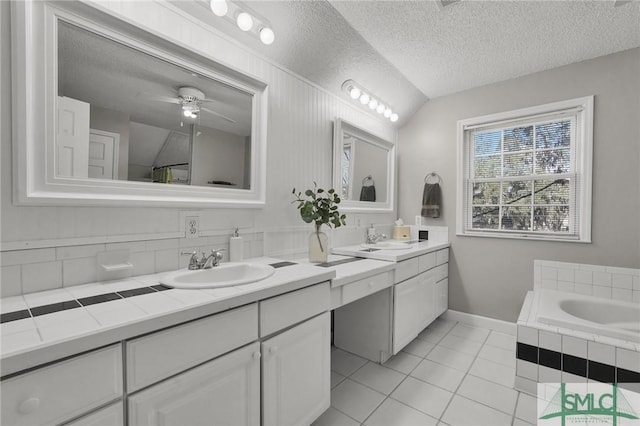 bathroom featuring a sink, a textured ceiling, two vanities, and tile patterned floors