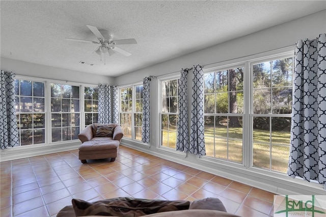 unfurnished sunroom with a ceiling fan