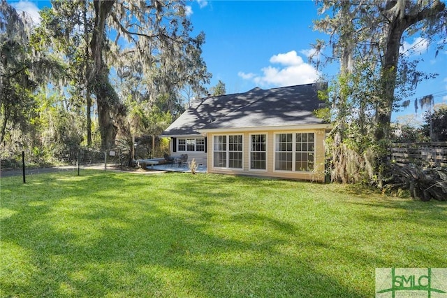 rear view of house featuring a yard