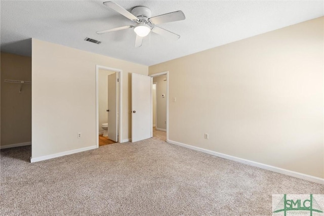 unfurnished bedroom with visible vents, carpet floors, baseboards, and a spacious closet