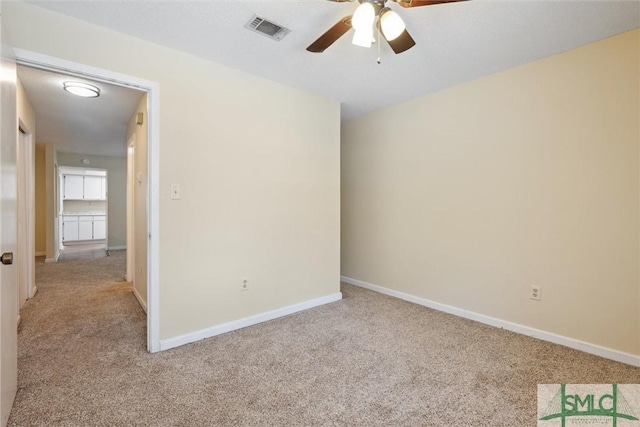 spare room featuring visible vents, baseboards, a ceiling fan, and carpet floors