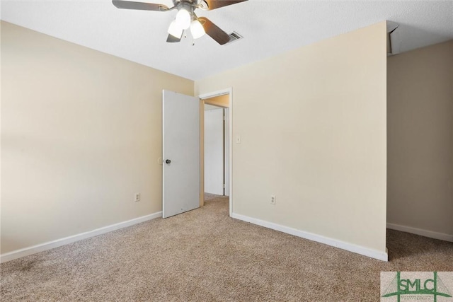 spare room with visible vents, baseboards, light colored carpet, and ceiling fan